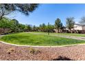 Expansive grassy park area with walking path, trees, and clear blue sky providing a serene outdoor space at 7237 Puddle Duck St, Las Vegas, NV 89166