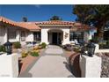 Home's elegant entrance with stone walkway, mature plants, and decorative lighting at 7660 Descanso Ln, Las Vegas, NV 89123