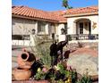 A home's front yard featuring desert landscaping, a terracotta roof, and ornate decorations at 7660 Descanso Ln, Las Vegas, NV 89123