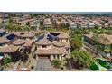 Overhead view of a Primary-planned community with numerous residences, lush landscaping, and mountain backdrop at 884 Loma Bonita Pl, Las Vegas, NV 89138