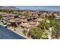 A beautiful aerial view of the community and home featuring a tile roof and solar panels at 884 Loma Bonita Pl, Las Vegas, NV 89138