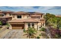 Beautiful two-story home with a tile roof, arched windows, and well-manicured landscaping at 884 Loma Bonita Pl, Las Vegas, NV 89138