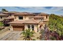 Stunning two-story home with tile roof, arched windows, and a three-car garage at 884 Loma Bonita Pl, Las Vegas, NV 89138