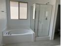 Bright bathroom featuring a soaking tub and separate glass-enclosed shower at 96 Via Franello, Henderson, NV 89011