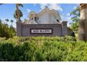 Welcoming entrance to Red Bluffs community featuring lush greenery and mature palm trees at 10116 Jacob Pl # 104, Las Vegas, NV 89144