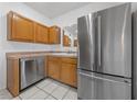 Functional kitchen featuring wood cabinets, stainless steel appliances, and tiled countertops at 10116 Jacob Pl # 104, Las Vegas, NV 89144
