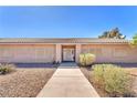Traditional home with a front yard, trimmed shrubs and a walkway to the front door at 2251 Thoroughbred Rd, Henderson, NV 89002