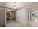 Well-lit hallway features tile floors, elegant chandelier, and access to other rooms at 2877 Paradise Rd # 2502, Las Vegas, NV 89109