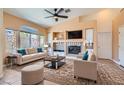 Bright living room featuring fireplace, ceiling fan, and view to the backyard at 2889 Anteres St, Las Vegas, NV 89117