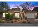 Charming single-story home featuring a stone facade, tile roof, desert landscaping, and an attached two-car garage at 8440 Footpath St, Las Vegas, NV 89166
