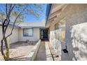 Single-story home featuring stucco siding, blue trim, a desert landscape, and a pathway to the front door at 1580 Albino Dr, Henderson, NV 89002