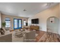Bright living room with hardwood floors, stylish furniture, and a large television for comfortable living at 1580 Albino Dr, Henderson, NV 89002