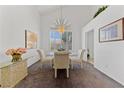 Formal dining area featuring elegant chandelier, vaulted ceilings, and bright window with charming window coverings at 3024 Pismo Beach Dr, Las Vegas, NV 89128