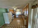 Functional kitchen features linoleum flooring, wooden cabinets, and a window overlooking the backyard at 4244 Gibraltar St, Las Vegas, NV 89121