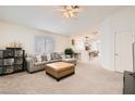 Bright living room featuring a comfortable sectional, neutral carpet, and a view into the dining area at 5114 Mascaro Dr, Las Vegas, NV 89122
