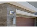 Close-up of the exterior showing the house number on the gray wood-look tile and garage door at 888 Cherry Glen Pl, Las Vegas, NV 89138