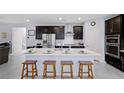 Modern kitchen with an island, stainless steel appliances, dark cabinets, and stylish bar stool seating at 888 Cherry Glen Pl, Las Vegas, NV 89138