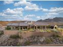 Desert home with a stone wall, tiled roof, and beautiful landscape at 1123 Christian Rd, Henderson, NV 89002