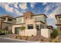Modern two-story home with stone accents, manicured landscaping, and a private gated entrance in a desert setting at 11990 Montague St, Las Vegas, NV 89138