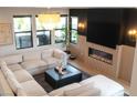 Stylish living room featuring a cozy fireplace, custom wood accent wall, and a plush, oversized sectional sofa at 11990 Montague St, Las Vegas, NV 89138