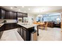 Modern kitchen featuring dark wood cabinets, stainless steel appliances, and granite countertops at 7119 Saddle Back Peak St, Las Vegas, NV 89166