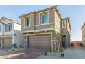 Two-story home featuring a two-car garage, brick paved driveway, and low maintenance landscaping at 10328 Apefly St, Las Vegas, NV 89141