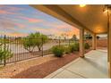 Inviting outdoor space featuring a covered patio with view of the desert landscape and sunset sky at 1172 Via Della Costrella, Henderson, NV 89011