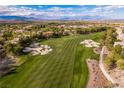 Scenic aerial view of a lush green golf course with sand traps in a community setting at 12056 Royal Dolnoch Ct, Las Vegas, NV 89141