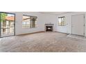 Bright living room with fireplace, carpet flooring, and sliding glass door access at 1575 W Warm Springs Rd # 121, Henderson, NV 89014