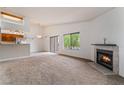 Spacious living room featuring a cozy fireplace, large window, and sliding door at 1575 W Warm Springs Rd # 121, Henderson, NV 89014