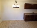 View of an eat-in kitchen with wood cabinets, a chandelier, and durable tile flooring at 212 Orland St # 17, Las Vegas, NV 89107