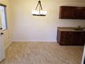 A kitchen with wood cabinets, tile floors, and space for a small dining area at 212 Orland St # 17, Las Vegas, NV 89107
