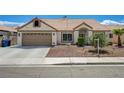 Attractive single-story home with desert landscaping, a two-car garage, and an American flag flying overhead at 2301 Jean Paul Ave, North Las Vegas, NV 89031