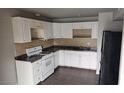 An inside view of the kitchen with a stove, sink, cabinets, and black refrigerator at 2525 Donna St # L, North Las Vegas, NV 89030