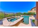 Backyard pool with a spa, stone trim and a safety fence, offering a view of the neighborhood at 2733 Auchmull St, Henderson, NV 89044