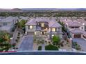 An impressive two-story home with a tile roof, stone accents, manicured landscaping, and a circular driveway at 34 Olympia Outlook Dr, Las Vegas, NV 89141