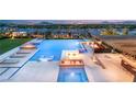 An luxurious backyard features a stunning pool with fire features, lounge chairs, and an outdoor kitchen with city views at 34 Olympia Outlook Dr, Las Vegas, NV 89141
