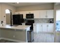 Bright kitchen with white cabinets, stainless steel appliances, gray backsplash, and hardwood floors at 3524 Silver Lantern Dr, North Las Vegas, NV 89032