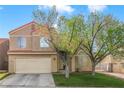 Two-story home featuring a two-car garage, neutral colored exterior, and a well-maintained lawn at 421 Raindance Dr, Henderson, NV 89014
