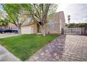 Well-manicured lawn, driveway to side gate and mature trees highlighting this two-story residence at 421 Raindance Dr, Henderson, NV 89014