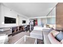 Open-concept living area with modern furnishings, sleek entertainment center, and comfortable sleeping space at 4381 W Flamingo Rd # 1003, Las Vegas, NV 89103