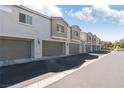 A row of townhomes featuring attached garages, neutral paint, and well-maintained landscaping at 4566 Mansart Ct # 1104, North Las Vegas, NV 89031