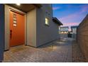 Inviting front entrance featuring a modern orange door with decorative windows and a well-lit walkway at 461 Cascade Heights Ave, Las Vegas, NV 89138