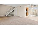 Open-concept space featuring staircase access to upper level and sliding glass doors to backyard at 4920 Larkspur St, Las Vegas, NV 89120