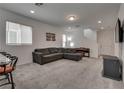 Spacious living room with carpet, a large grey sofa, and staircase access at 5256 Sherwood Forest Ln, Las Vegas, NV 89122