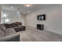 Open living room features grey sofa, mounted television, and lots of natural light at 5256 Sherwood Forest Ln, Las Vegas, NV 89122