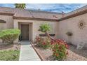 Close-up view of the home's entry with landscaped garden featuring red roses and palm tree at 6048 Pele St, North Las Vegas, NV 89031