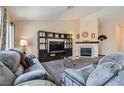 Comfortable living room featuring plush sofas, a fireplace, and ample natural light from large windows at 6048 Pele St, North Las Vegas, NV 89031