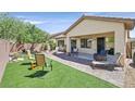Spacious backyard with lush artificial turf, a brick patio, and a variety of outdoor seating options at 6072 Canter Glen Ave, Las Vegas, NV 89122