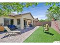 Large backyard area with ample seating, a covered patio, and a well-maintained lawn at 6072 Canter Glen Ave, Las Vegas, NV 89122